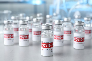 Glass vials with COVID-19 vaccine on light table