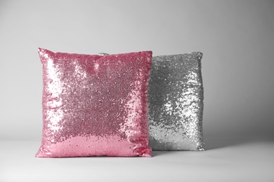 Photo of Shiny decorative pillows on light background