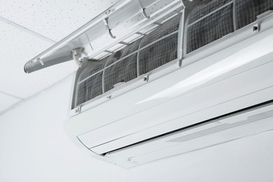 Photo of Modern air conditioner on white wall, closeup