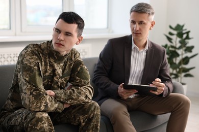 Professional psychotherapist working with military man in office