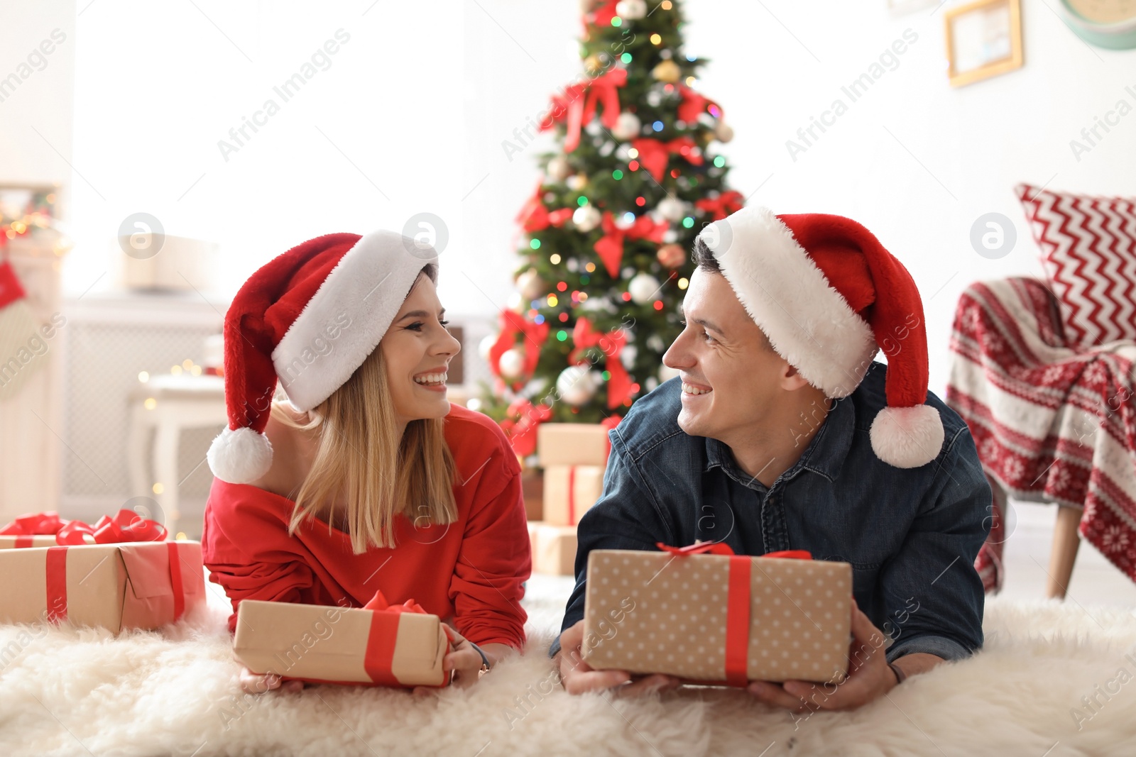 Photo of Young couple with Christmas gifts at home