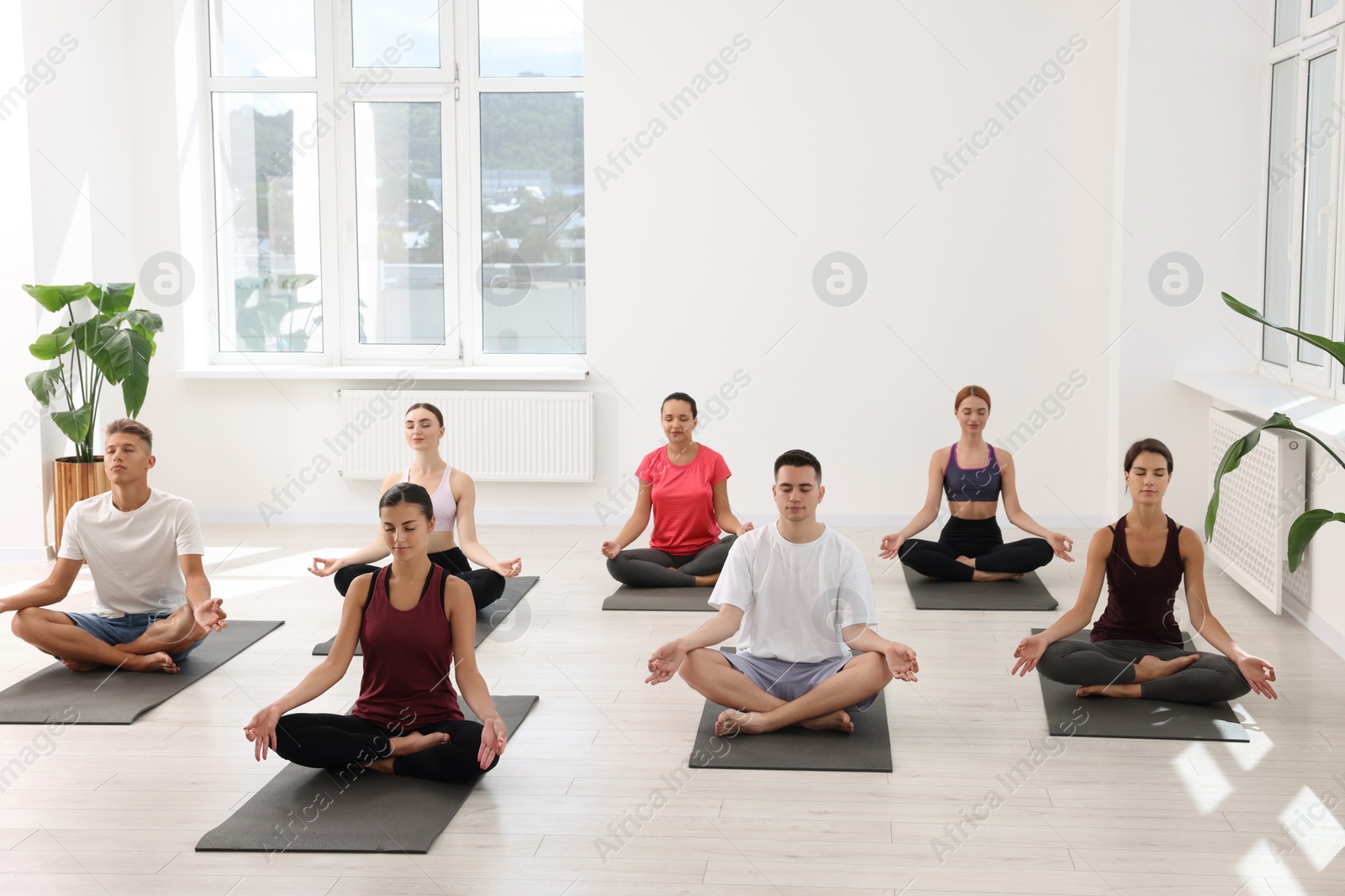 Photo of Group of people practicing yoga on mats indoors