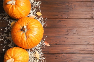 Photo of Flat lay composition with pumpkins and space for text on wooden background. Autumn holidays