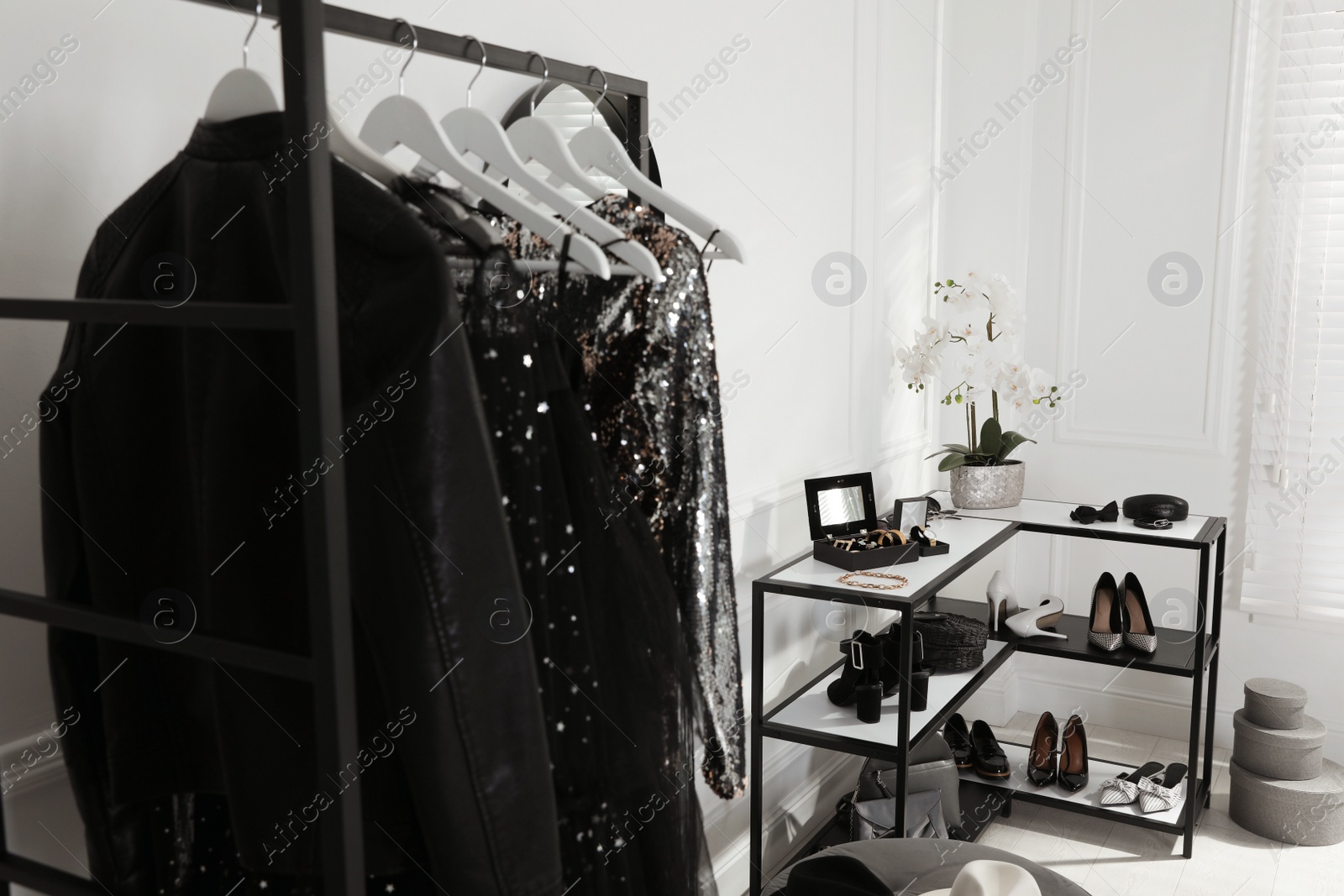 Photo of Rack with stylish women's clothes, shoes and accessories in dressing room