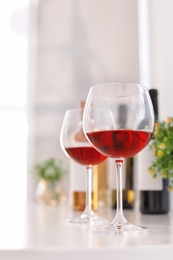 Photo of Glasses and bottles with delicious wine on table indoors