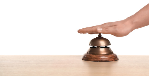 Photo of Man ringing hotel service bell at wooden table