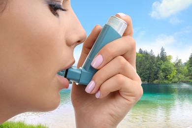 Woman using asthma inhaler near lake, closeup. Emergency first aid during outdoor recreation
