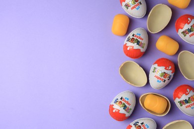 Photo of Sveti Vlas, Bulgaria - June 29, 2023: Kinder Surprise Eggs and plastic capsules on violet background, flat lay. Space for text
