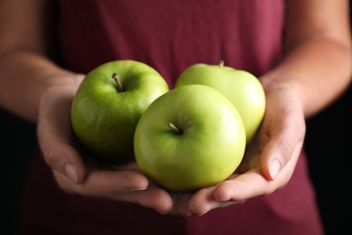 Photo of Farmer holding fresh ripe apples, closeup view