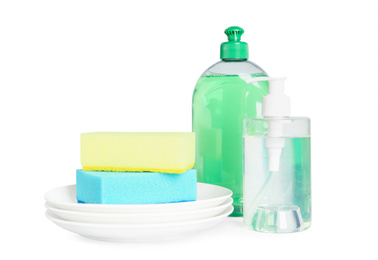 Photo of Detergents, plates and sponges on light background. Clean dishes