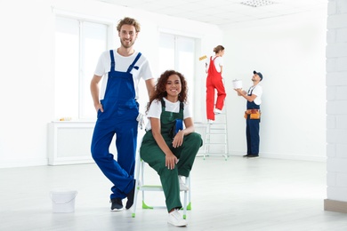 Photo of Team of professional painters with tools working indoors