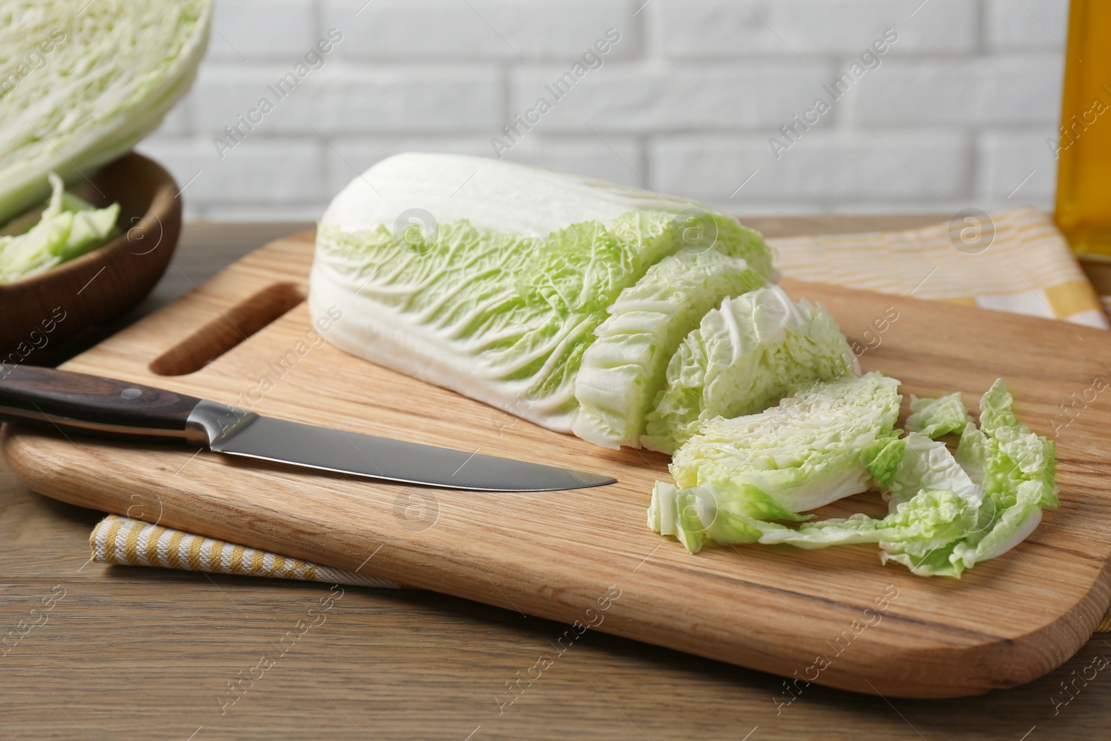 Photo of Cut fresh Chinese cabbage and knife on wooden table