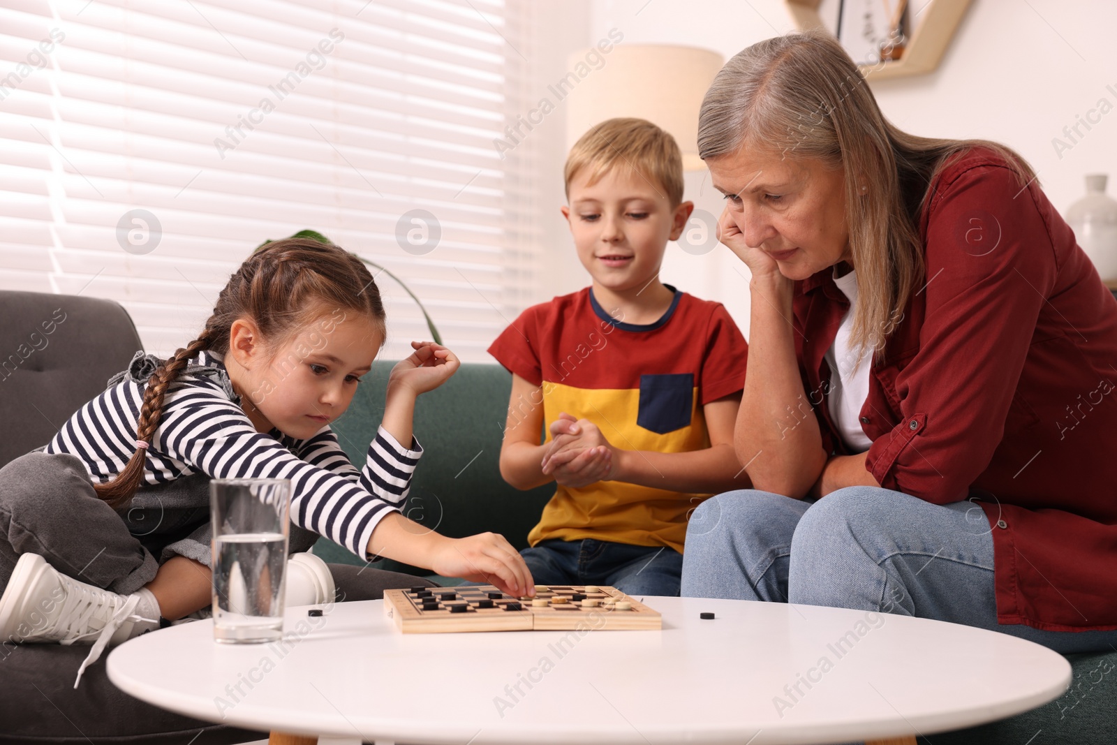 Photo of Family playing checkers at coffee table in room