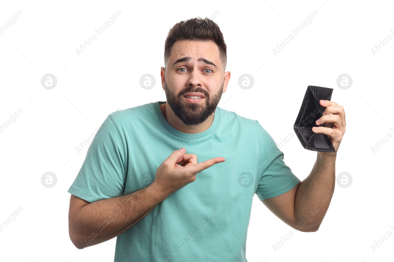 Photo of Confused man pointing at empty wallet on white background