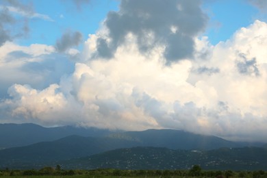 Photo of Picturesque view of green hills under clouds