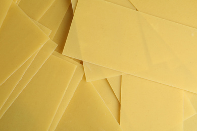 Photo of Pile of dry lasagna sheets as background, closeup