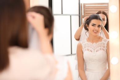 Professional hairdresser working with young bride in salon