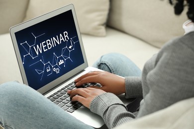 Image of Online webinar, web page on computer screen. Woman using laptop on sofa, closeup