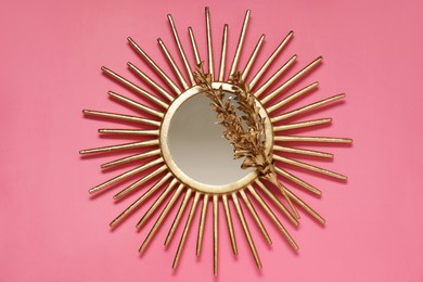 Photo of Golden mirror and dried flower on pink background, top view