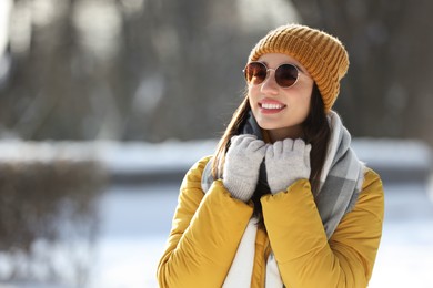 Portrait of beautiful young woman with sunglasses on winter day outdoors