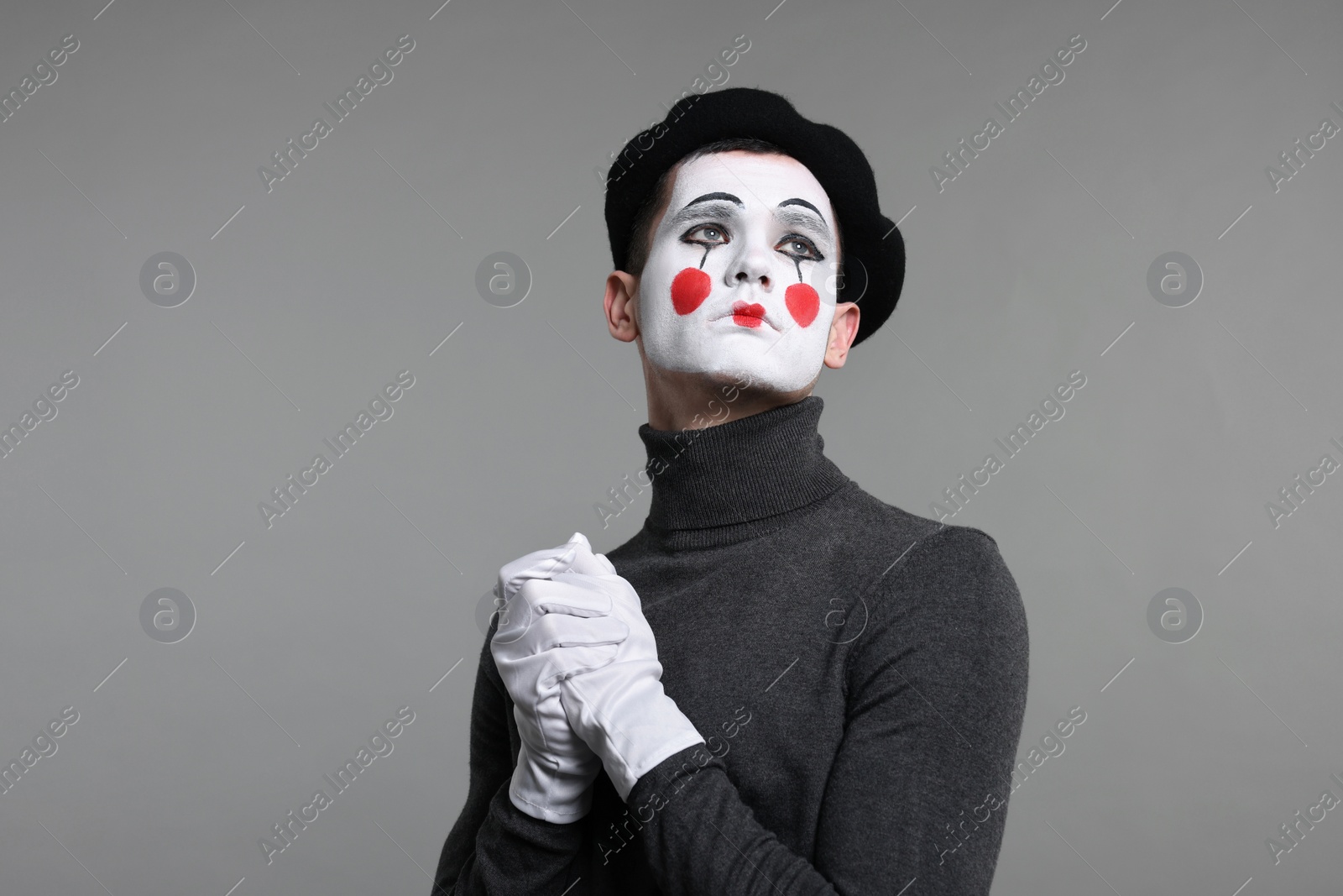 Photo of Portrait of mime artist in beret on grey background