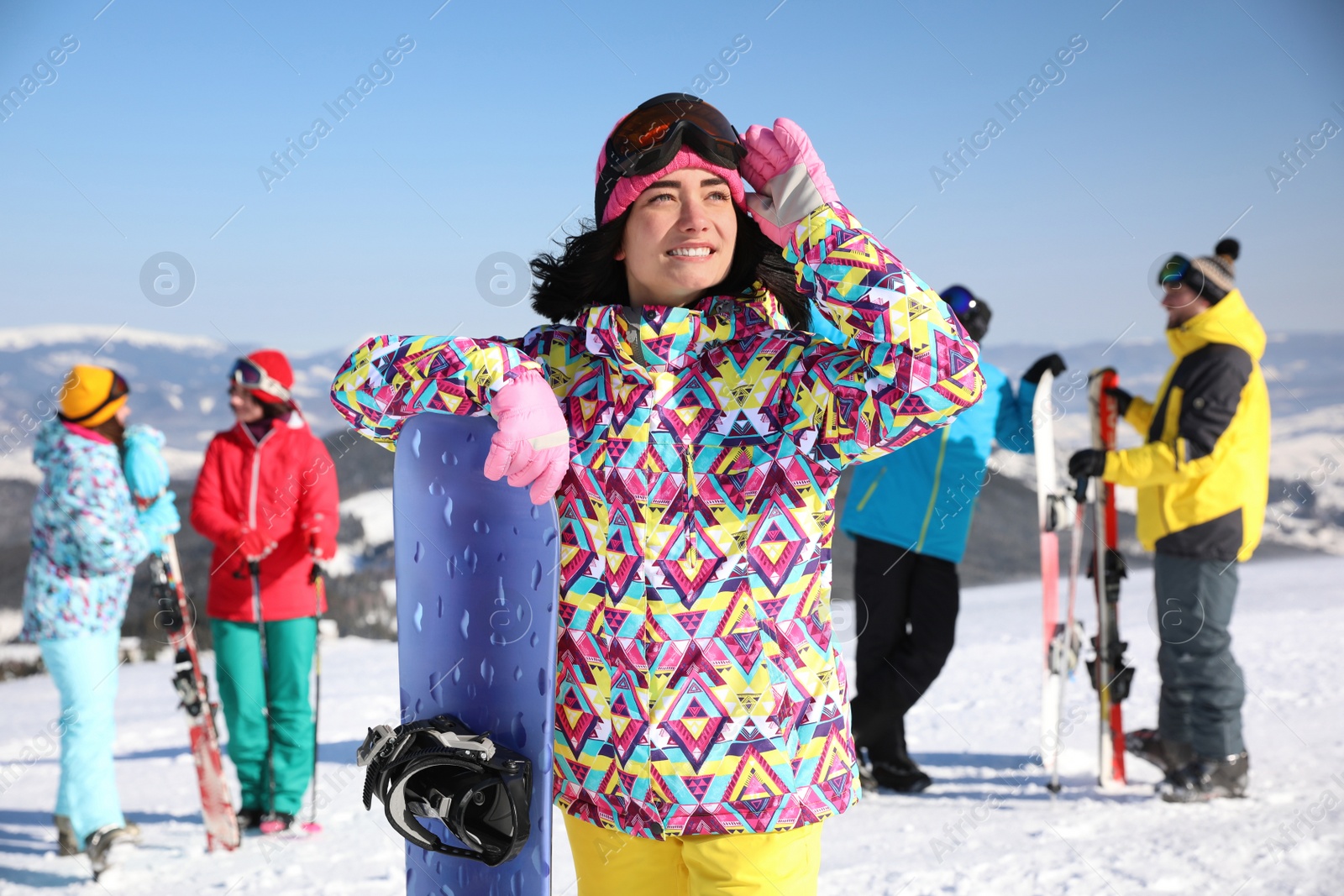 Photo of Young woman with snowboard at ski resort. Winter vacation