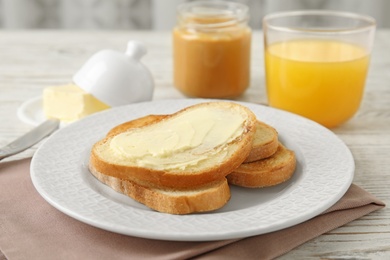 Photo of Plate with tasty bread for breakfast on white wooden table