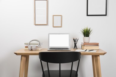 Cozy workspace with laptop and stationery on wooden desk at home