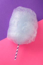 Photo of Sweet light blue cotton candy on color background, top view