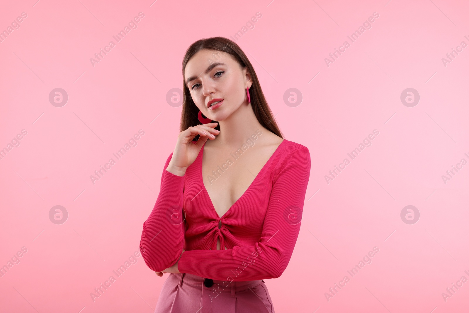 Photo of Beautiful young woman in pink clothes on color background