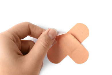 Photo of Woman putting sticking plaster on white background, top view. First aid item