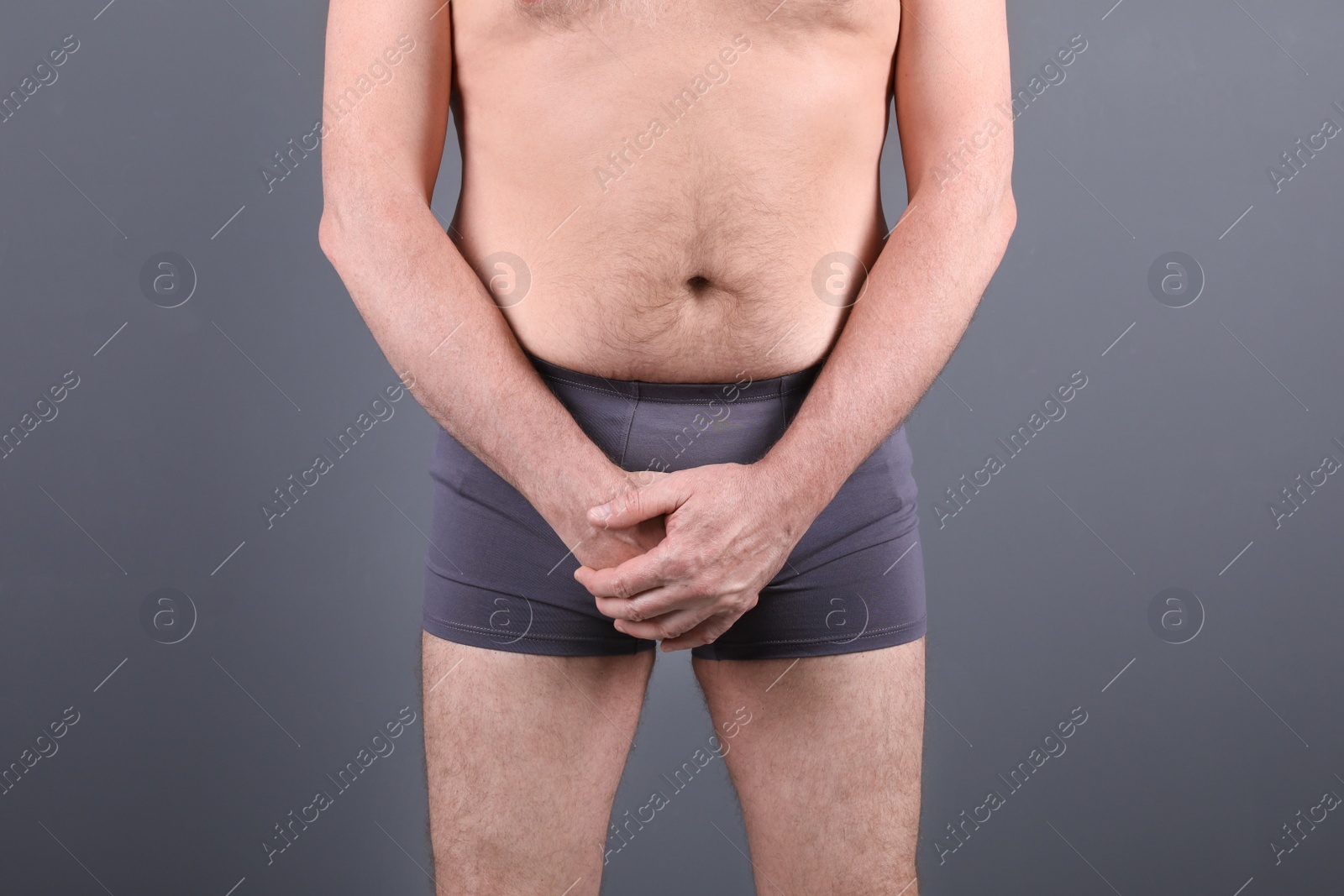 Photo of Mature man with urological problems suffering from pain on grey background