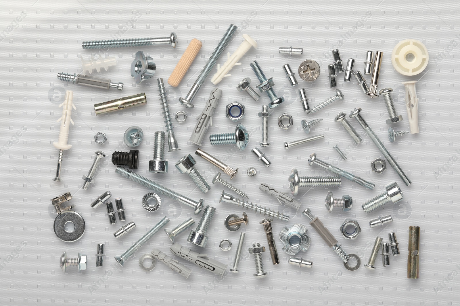 Photo of Many different fasteners on plastic surface, flat lay