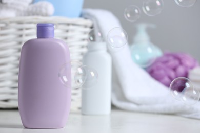 Photo of Bottle of baby cosmetic product on white table, space for text