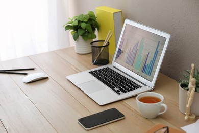 Photo of Stylish workplace with laptop on wooden desk. Interior design