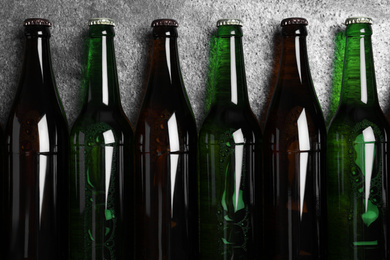 Photo of Bottles with beer on grey table, flat lay