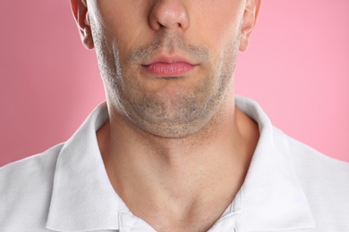 Young man with double chin on pink background, closeup