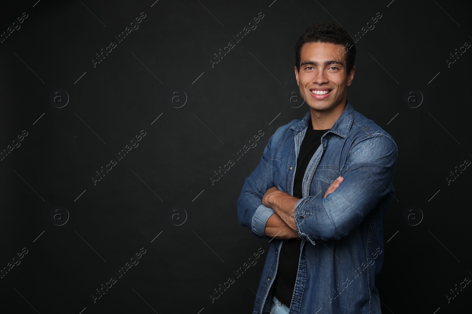 Photo of Handsome young African-American man on black background. Space for text