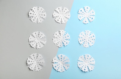 Photo of Many paper snowflakes on color background, flat lay
