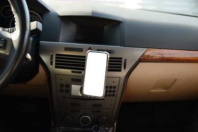 Photo of Holder with modern mobile phone in car. Mockup for design