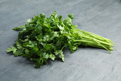 Photo of Bunch of fresh green parsley on grey background