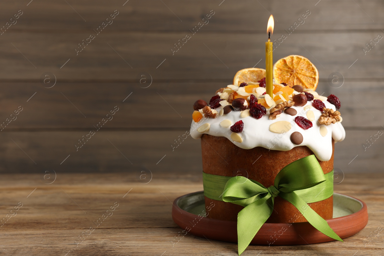 Photo of Tasty Easter cake with dried fruits and nuts on wooden table. Space for text