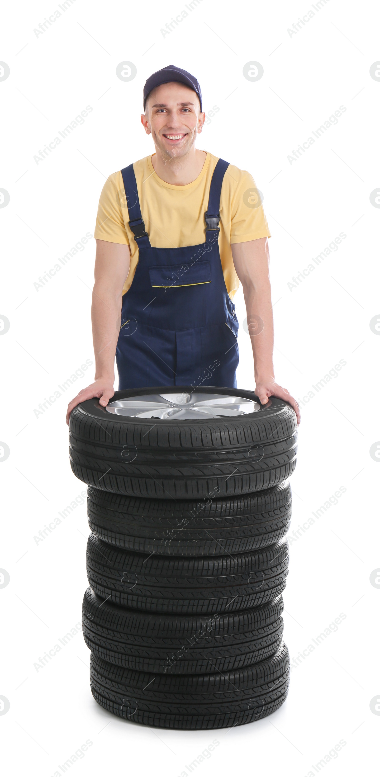 Photo of Male mechanic with car tires on white background