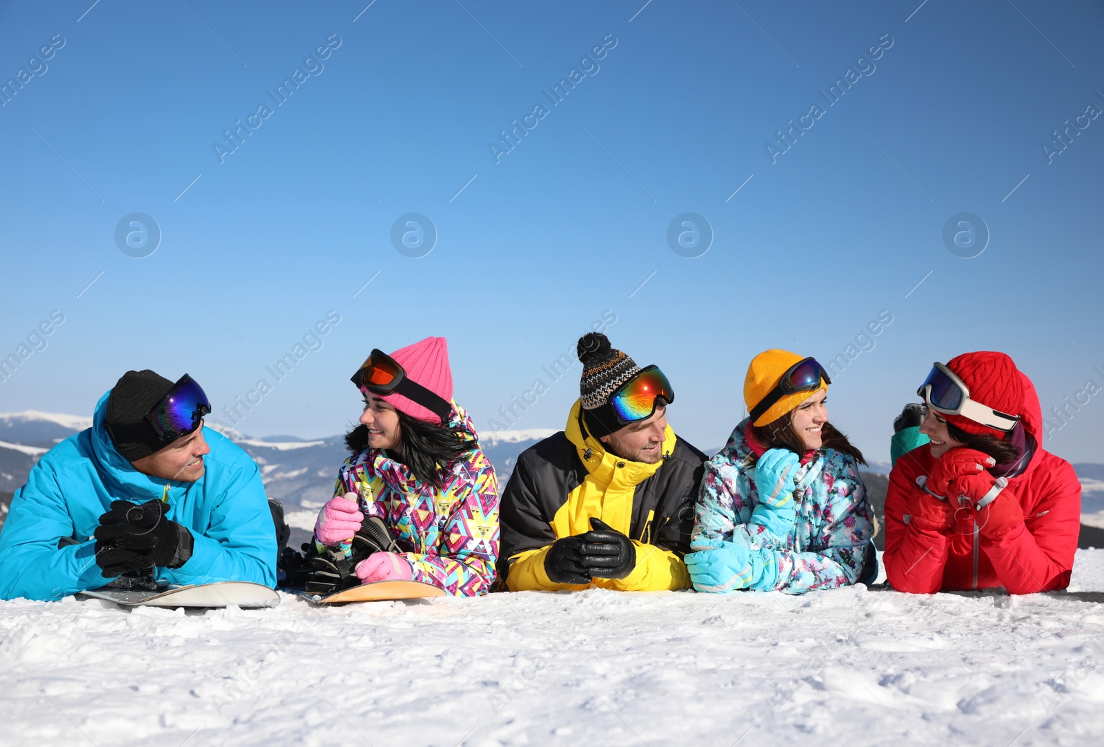 Photo of Group of friends lying on hill. Winter vacation