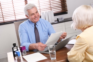 Senior notary working with client in office