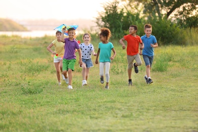 Cute little children playing with kite outdoors