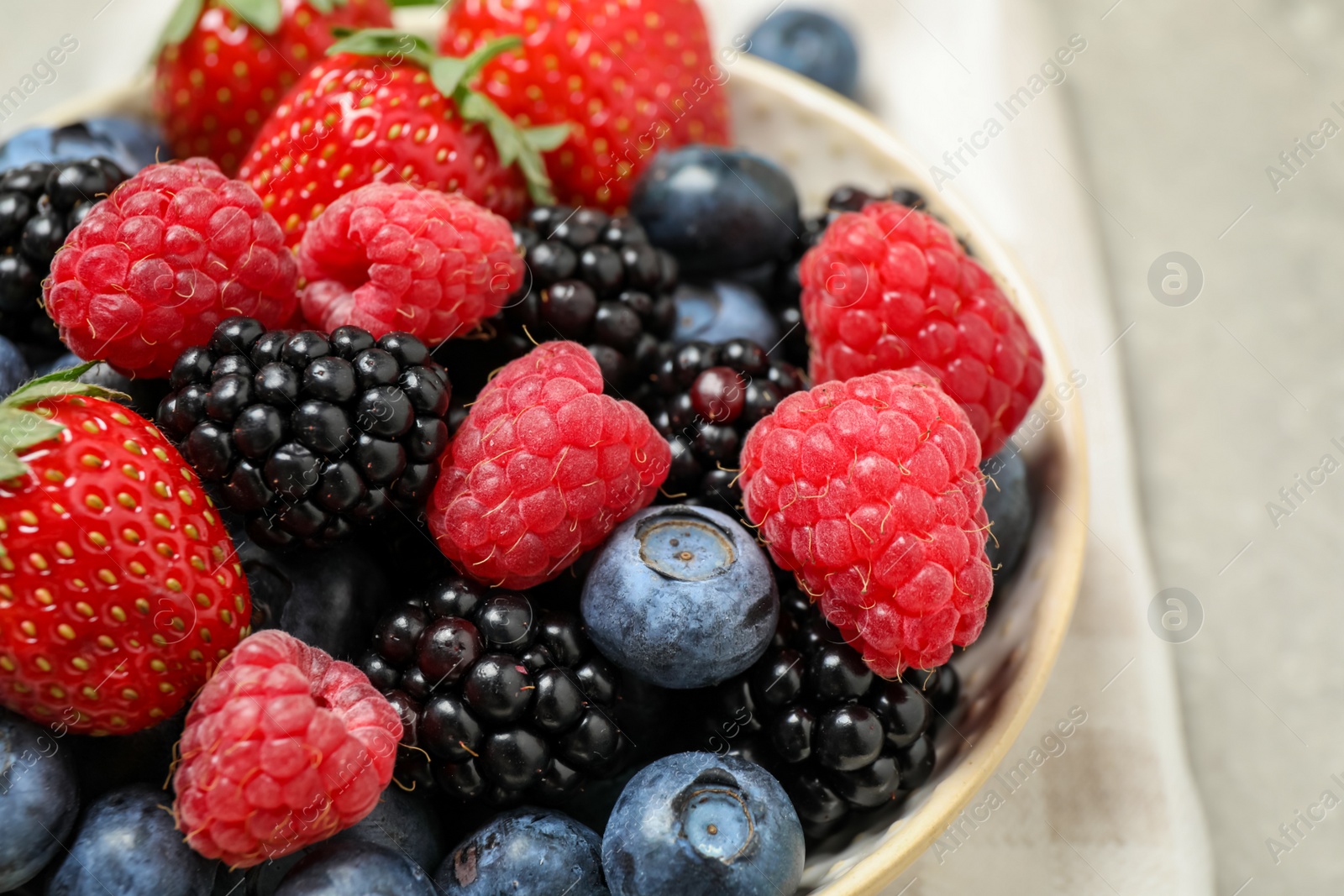 Photo of Mix of different fresh berries in bowl on table, closeup