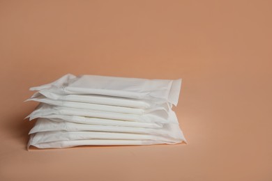 Photo of Menstrual pads on pale orange background. Gynecological care