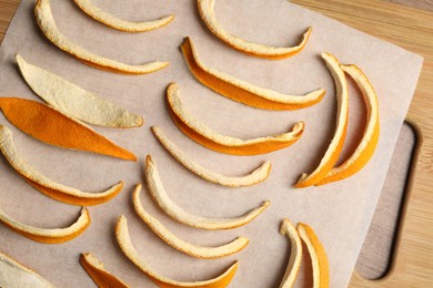 Many dry orange peels on wooden table, top view
