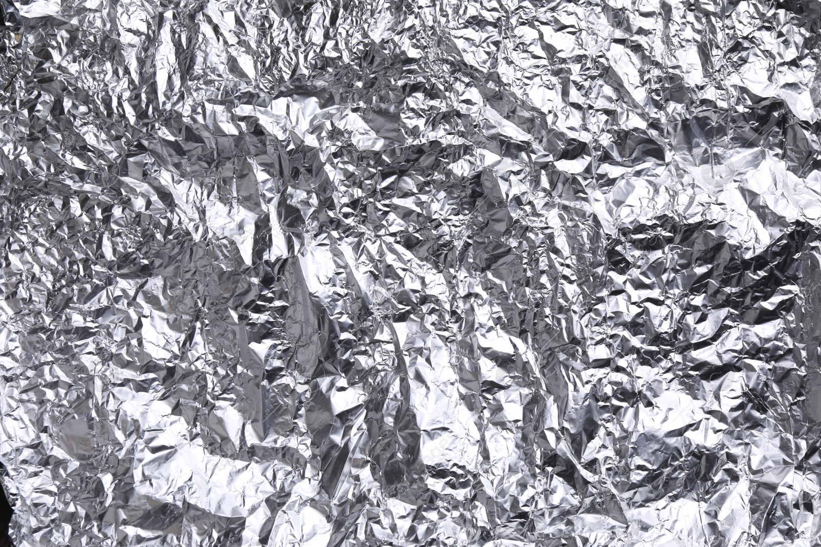 Photo of Crumpled silver foil as background, closeup view